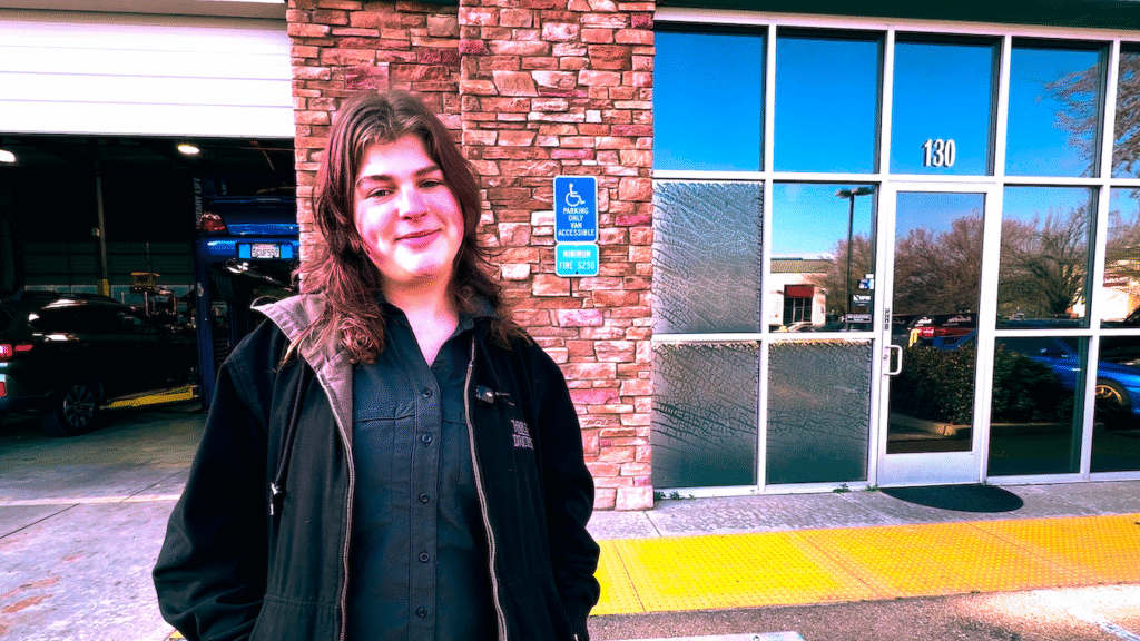 Service Advisor, Autumn, standing in front of the shop.