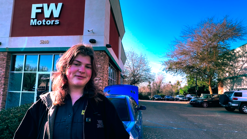 woman standing in front of auto shop
